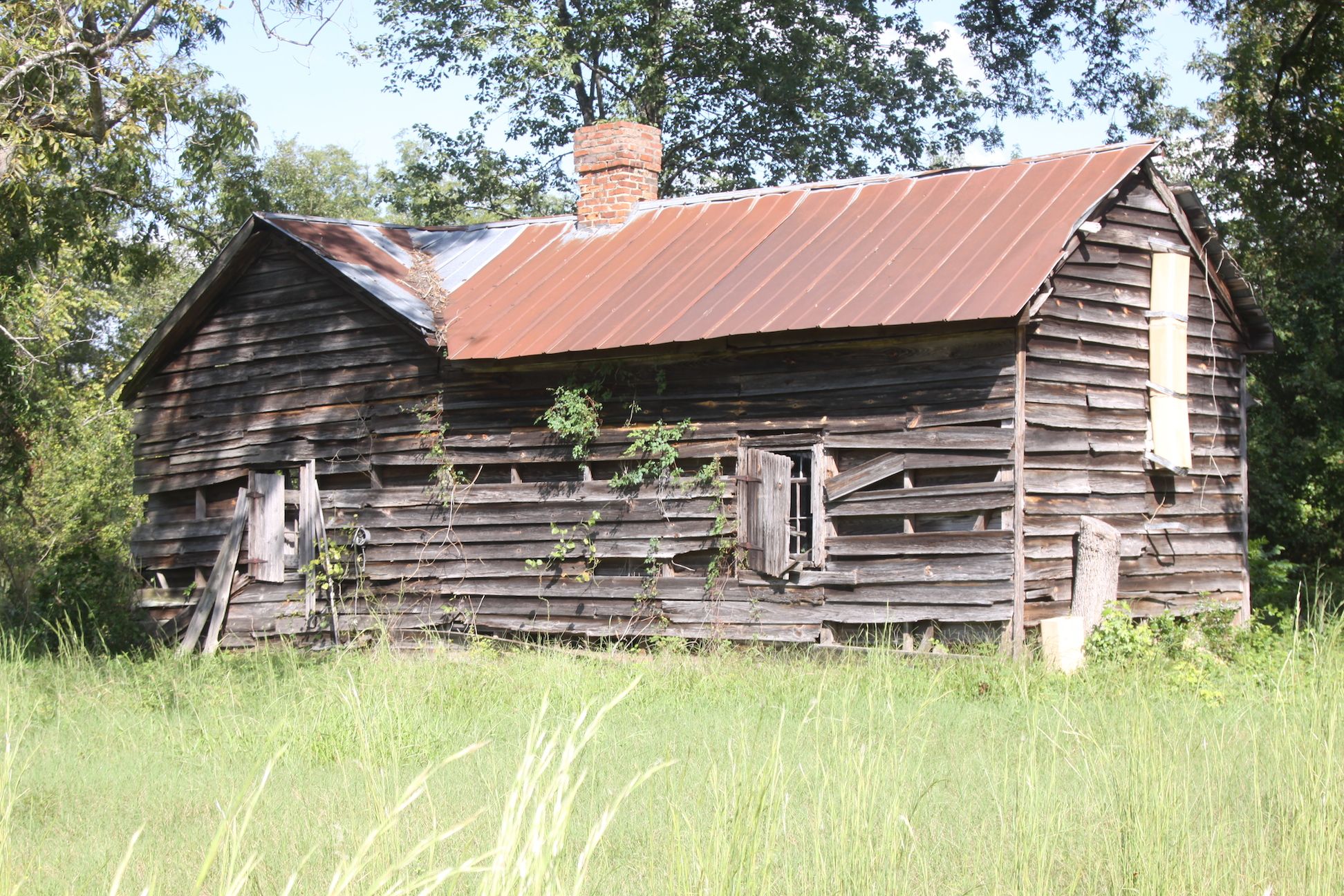 Front elevation of Jane James House featuring brick chimney and original footprint surrounded by rural landscape