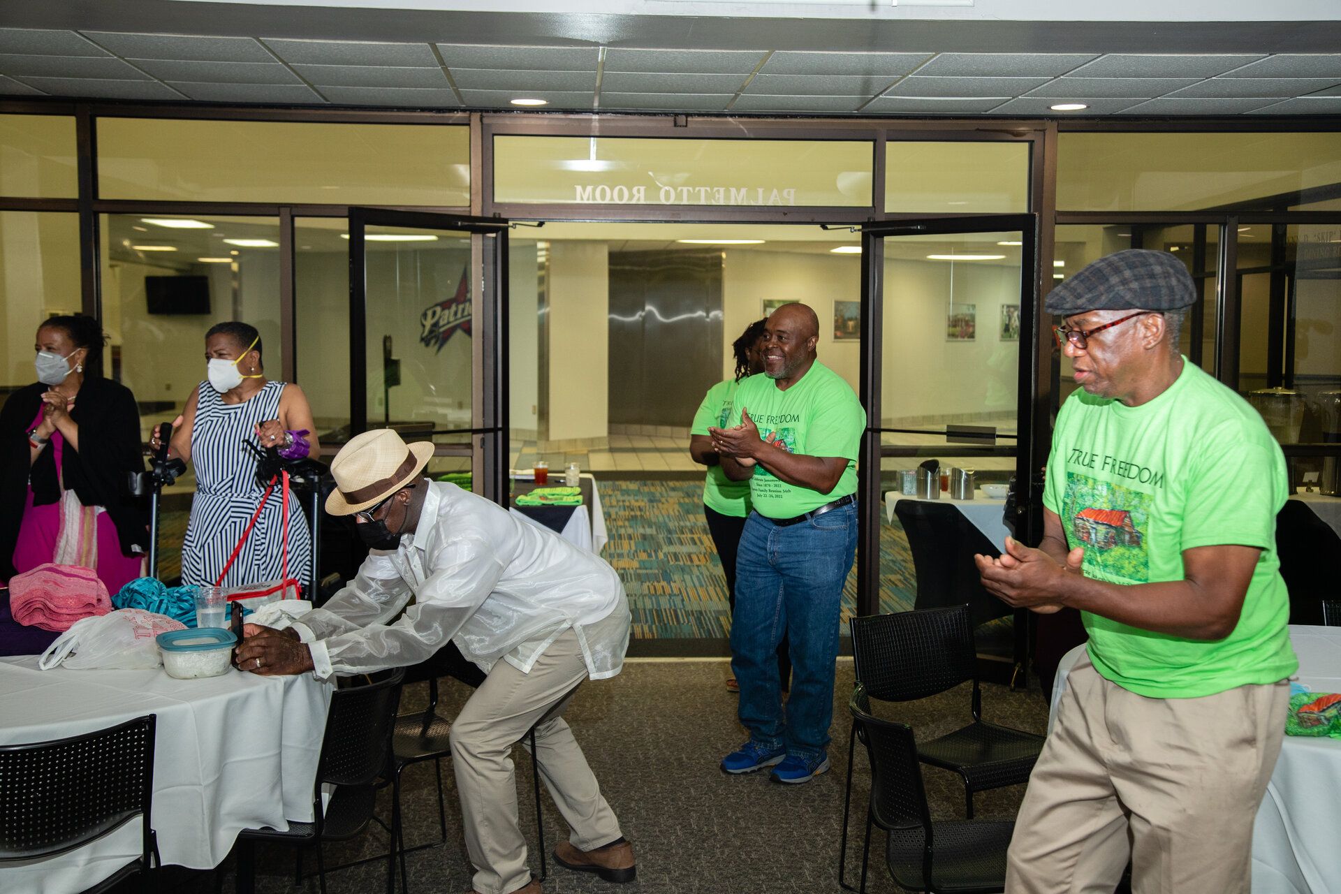 Community members in bright green shirts dancing and celebrating together at the Jamestown Foundation Festival